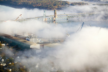 Aerial view of fog over Bath Iron Works and Kennebec River in Maine.  Bath Iron Works is a leader in surface combatant design and construction with a $27 million dollar contract from the Navy for maintenance, repair and upgrades to Aegis destroyers.