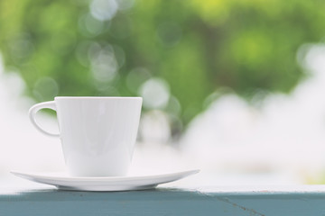 White coffee cup with outdoor view background - vintage filter e