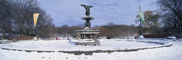 Obraz premium Panoramic view of water fountain covered with fresh winter snow in Central Park, Manhattan, New York City