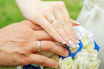 Obraz na płótnie Canvas Groom and brides hands with rings, closeup view