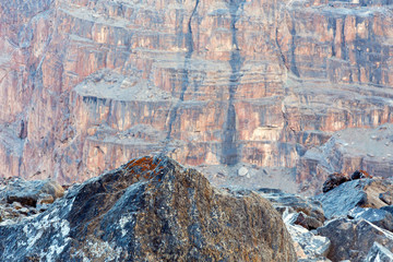 Sharp Grey Rocky Ridge and Blurred Orange Mountain Wall on Background