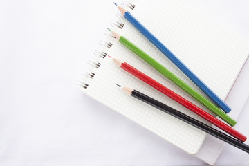Fototapeta premium Color pencils and the ring binder book isolated on white background