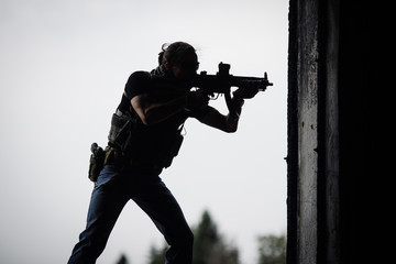 Silhouette of terrorist with assault rifle - obrazy, fototapety, plakaty