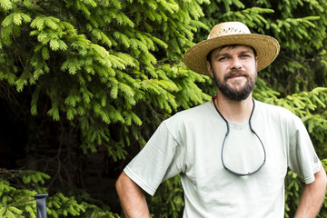 portrait of young man with beard and hat in a mountain pine fore