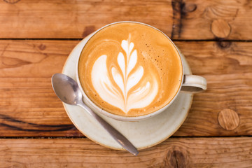 Hot art Latte Coffee in a cup on wooden table.