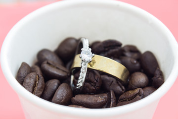 Wedding rings in the cup with coffee beans
