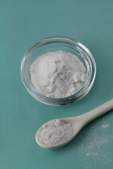Baking soda, Sodium bicarbonate in glass bowl and spoon on wooden table