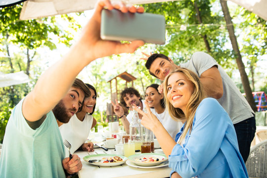 Friends making selfie photo in outdoor restaurant