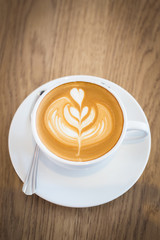 Hot art Latte Coffee in a cup on wooden table