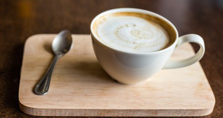 hot latte art coffee  on wooden table, vintage and retro style.