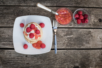 Fototapeta na wymiar Pancakes mit Himbeeren, Sahne und Himbeer-Nektarinen-Marmelade