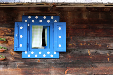 blue window on wooden hut wall