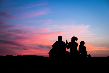 Fototapeta na wymiar Silhouette of a family enjoying a beautiful sunset