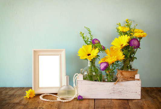 summer bouquet of flowers next to blank vintage photography frame