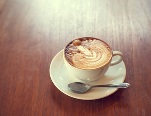 cup of coffee on table in cafe , vintage or retro color toned
