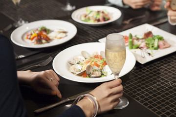 Women are eating Italian food while drinking champagne