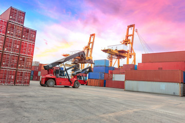 forklift handling container box loading to truck in import export logistic zone