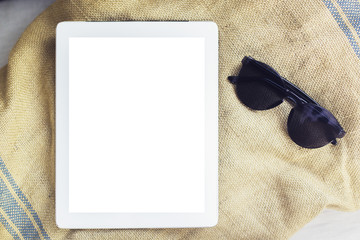 Blank digital tablet with sunglasses on a towel, mock up
