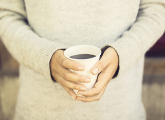 Girl's hands holding a cup of coffee