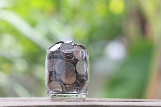 silver coin in glass is placed on a wood floor with colorful bok