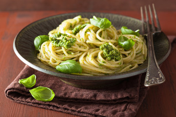 spaghetti pasta with pesto sauce over rustic table