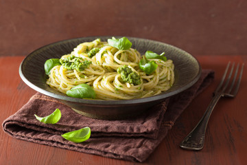 spaghetti pasta with pesto sauce over rustic table