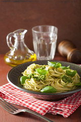 spaghetti pasta with pesto sauce over rustic table