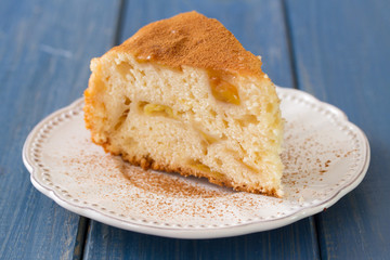apple pie on white plate on blue wooden background