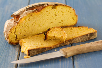 corn bread with knife on blue wooden background
