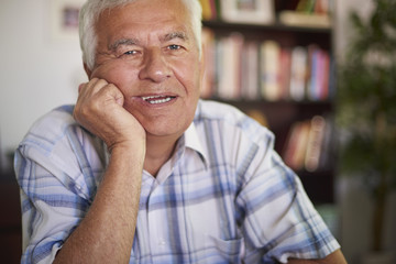 Portrait of cheerful senior man at the table