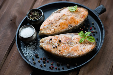 Frying pan with roasted norwegian salmon fillets, studio shot