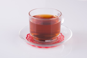 Tea in glass cup or glass cup of black tea on a background.