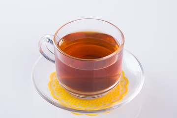 Tea in glass cup or glass cup of black tea on a background.