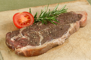 sirloin steak uncooked on wooden board