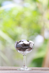 silver coin in glass is placed on a wood floor with colorful bok