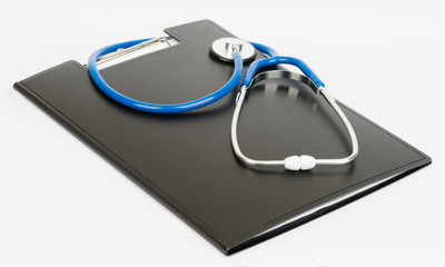 Medical stethoscope and clipboard on a white background