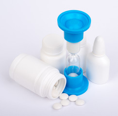 Hourglass and scattered pills from a bottle