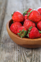 Ripe strawberries in a brown bowl