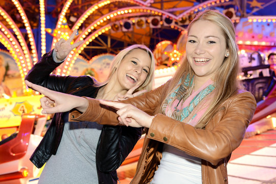 Frau auf Kirmes und Jahrmarkt hat Spa&szlig; und Freude mit Freundin und ist albern und lustig