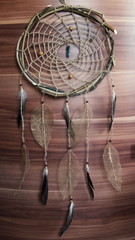 Fototapeta na wymiar Photo Dreamcatcher in ethnic style, hand-made from eco materials - willow branches, flax thread, feathers, skeletonized leaves and wooden beads