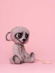 Cute sad little stuffed toy mouse sitting on a pink background