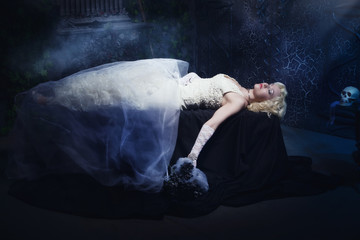 Sleeping Beauty. Beautiful lifeless bride in white dress lying o