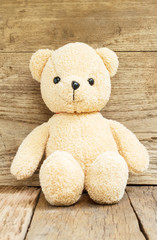 Teddy Bear toy alone on wood background