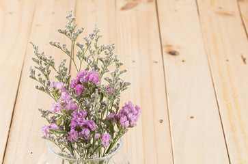 Fototapeta na wymiar statice flower bouquet on wood background