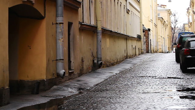 Narrow street in the historic part of Vasilievsky island covered with stone pavers, St. Petersburg, Russia
