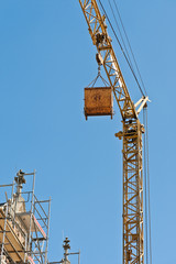 Ein Kran mit Klappk&uuml;bel unter blauem Himmel - Froschperspektive
