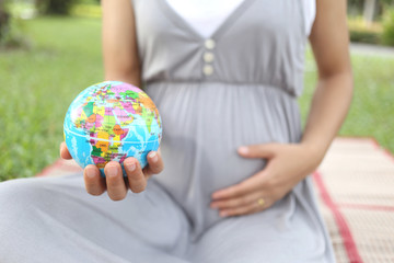 Pregnant women show Globe model in hand.