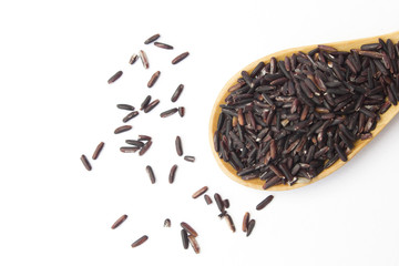 Dark violet rice on wooden spoon isolated on white background