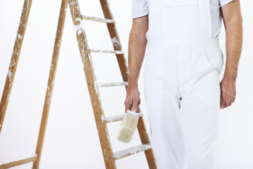 painter man at work with a paint brush and ladder