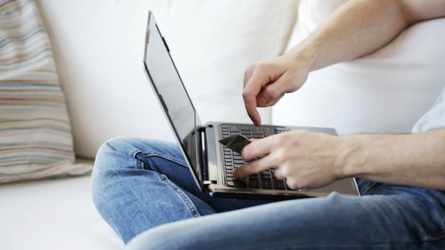 close up of man with laptop and credit card